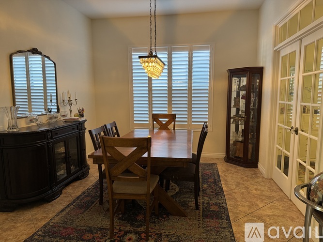 A dining room with a wooden table and chairs.