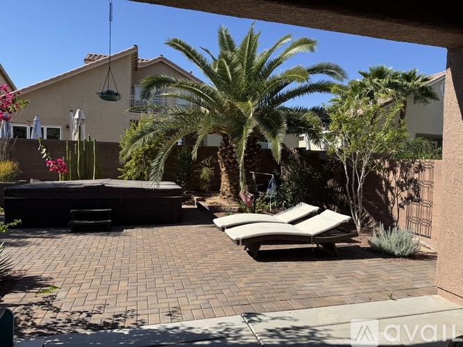 A patio with a table and chairs surrounded by palm trees.