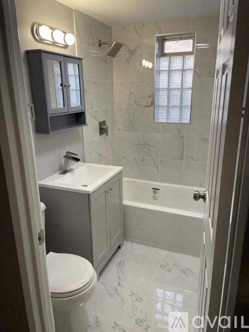 A white bathroom with a toilet, sink, and tub.