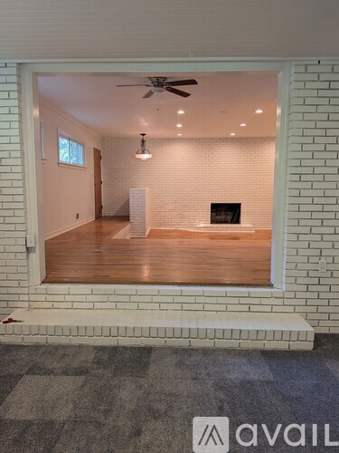 A room with a ceiling fan and a fireplace.