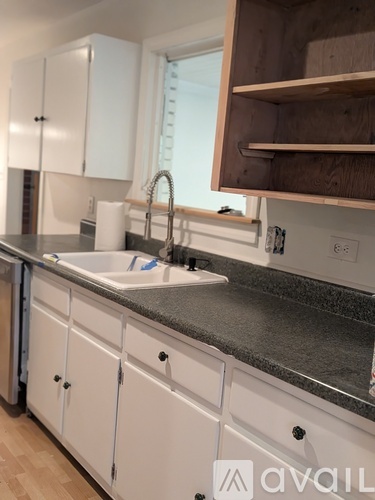 A kitchen with white cabinets and a granite countertop.
