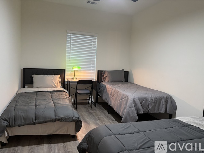 A bedroom with two beds and a chair.