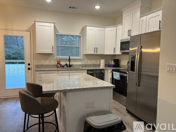 A kitchen with a granite countertop and stainless steel appliances.