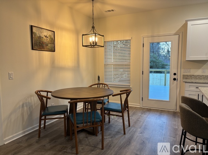 A dining room with a wooden table and chairs.