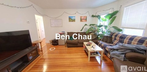 A living room with wooden floors and furniture, including a couch and a coffee table.