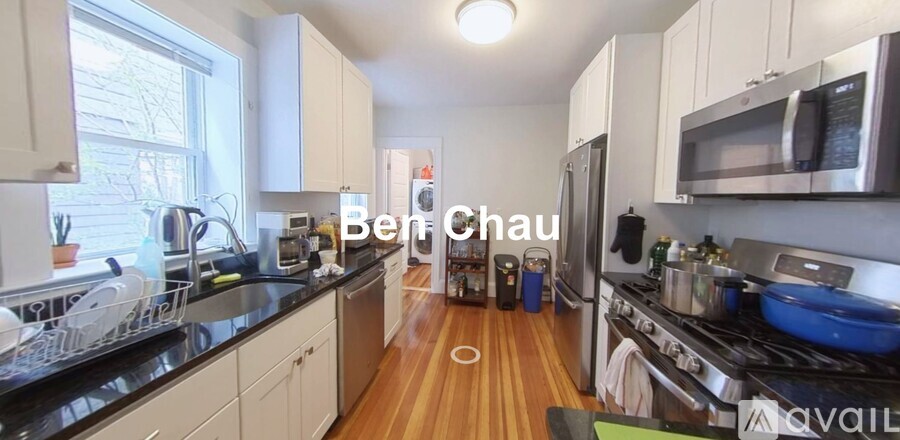 A kitchen with a black counter top and white cabinets.