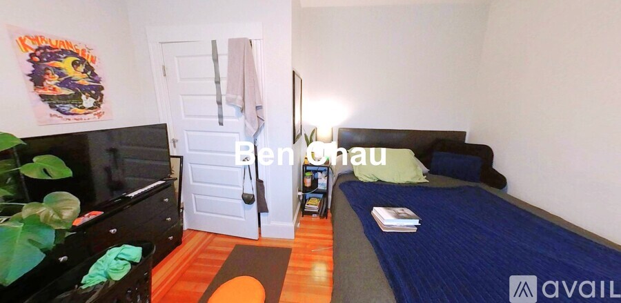 A bedroom with a bed, dresser, and a poster on the wall.