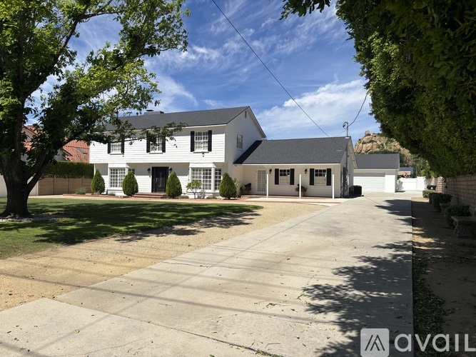 A house with a driveway and trees in front.