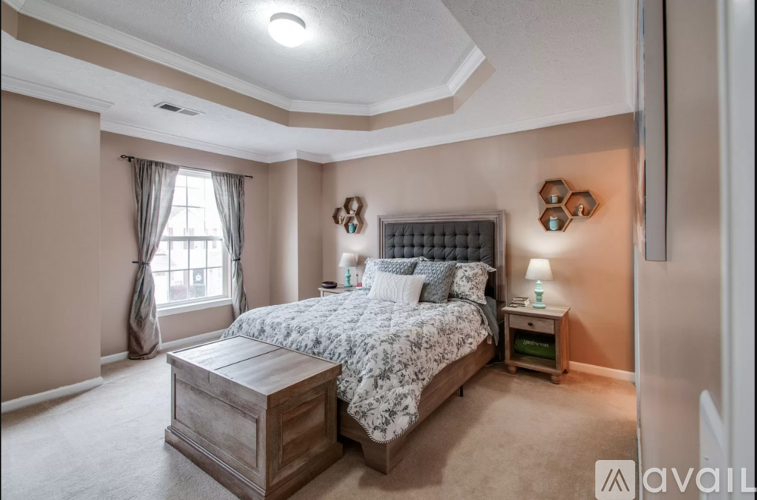A bedroom with a large bed and a wooden nightstand.