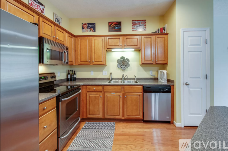A kitchen with wooden cabinets and a stainless steel refrigerator.