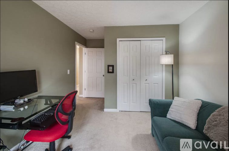A living room with a red chair and a green couch.
