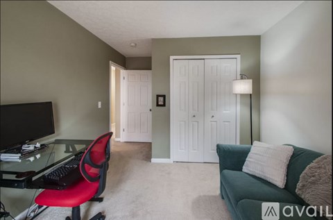 A living room with a red chair and a green couch.