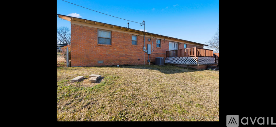 A brick house with a porch and a fence.