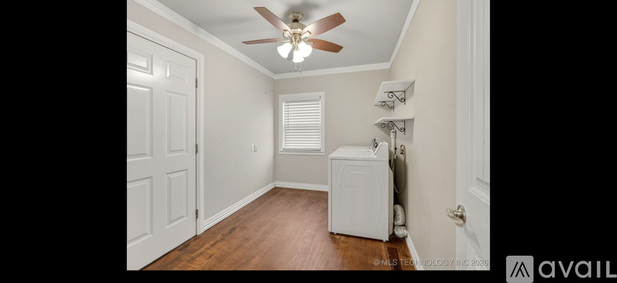 A room with a ceiling fan and a window with blinds.