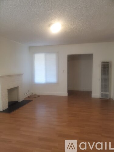 A room with a fireplace and wooden floors.