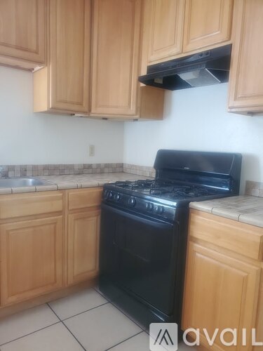 A kitchen with wooden cabinets and a black stove top oven.
