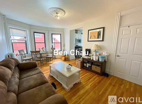 A living room with a brown leather couch and a white coffee table.