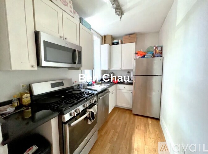 A kitchen with a stove, microwave, and refrigerator.