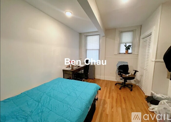 A bedroom with a blue bedspread and a bed in the center of the room.