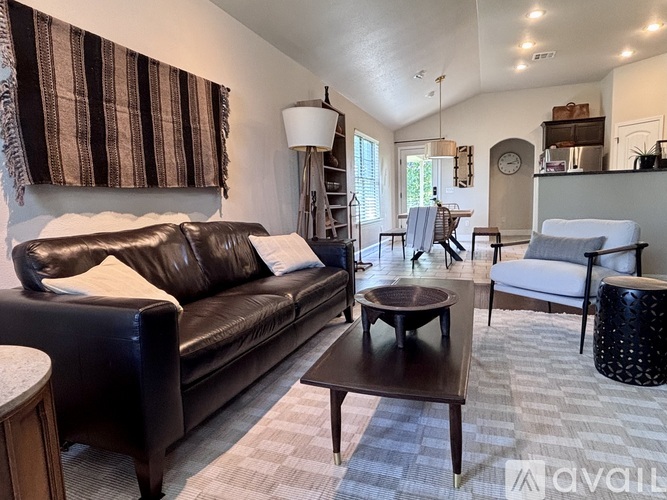 A living room with a brown leather couch and a wooden coffee table.