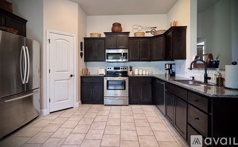 A kitchen with black cabinets and a white door.