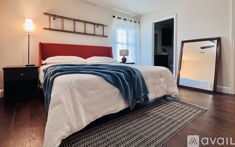 A bedroom with a bed covered in a white and blue striped comforter.