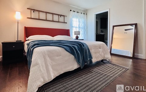 A bedroom with a bed covered in a white and blue striped comforter.