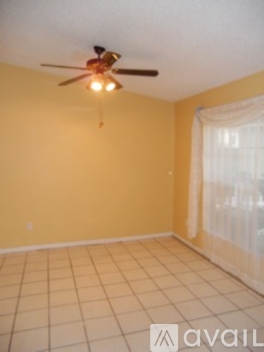 A room with a ceiling fan and tiled floor.