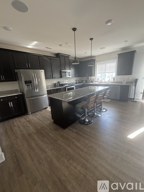 A modern kitchen with dark wood cabinets and stainless steel appliances.