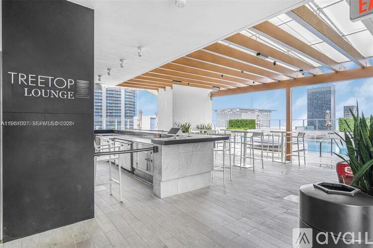 A modern lounge area with a bar and a view of the city.