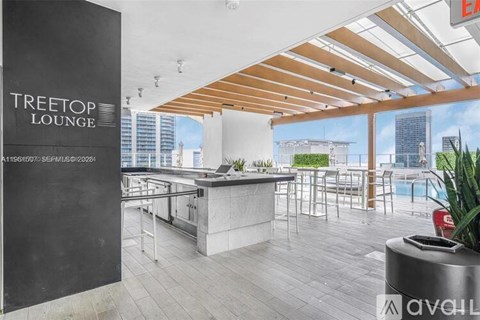 A modern lounge area with a bar and a view of the city.