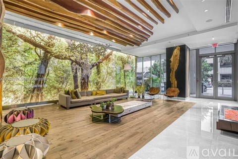 A modern living room with a large tree mural on the wall.