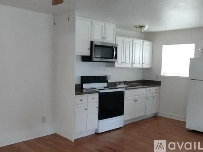 A kitchen with white cabinets and black appliances.