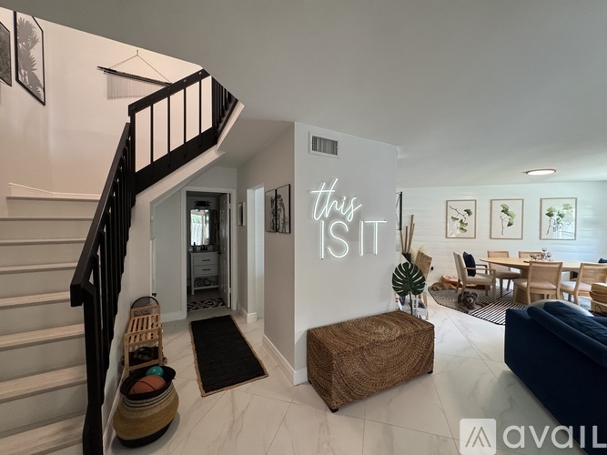 A living room with a couch, a coffee table, and a dining table with chairs.