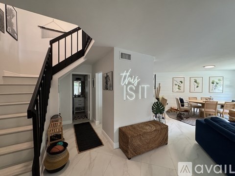 A living room with a couch, a coffee table, and a dining table with chairs.