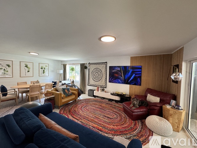 A living room with a blue couch and a rug.