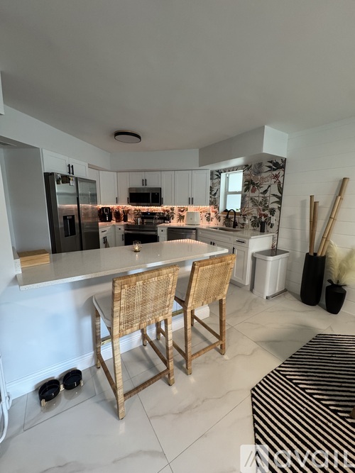 A kitchen with a white countertop and a striped bench.