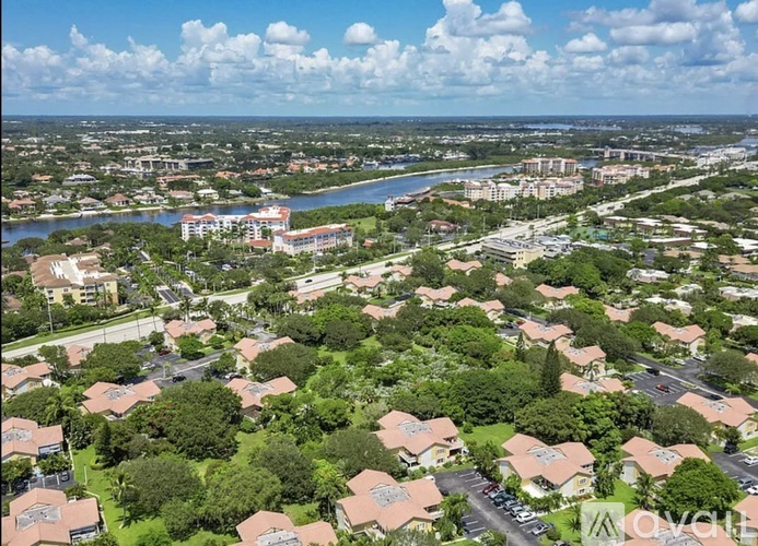 A bird's eye view of a residential area with houses, trees, and a river in the distance.