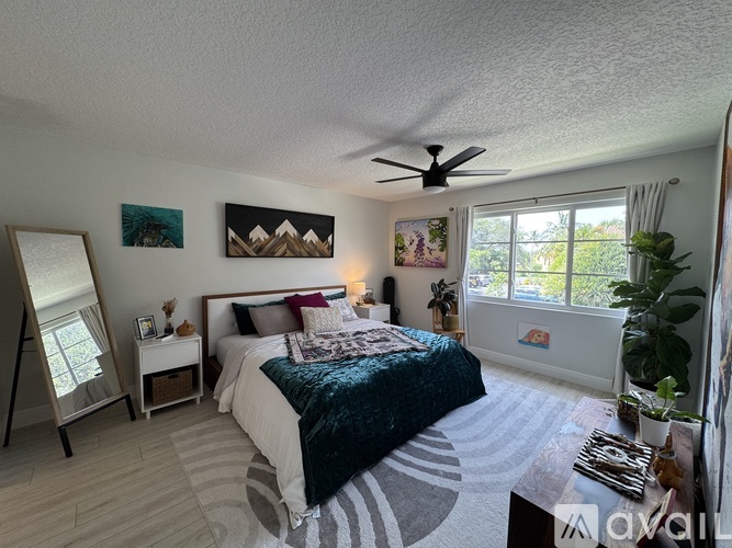 A bedroom with a bed, a ceiling fan, and a window.