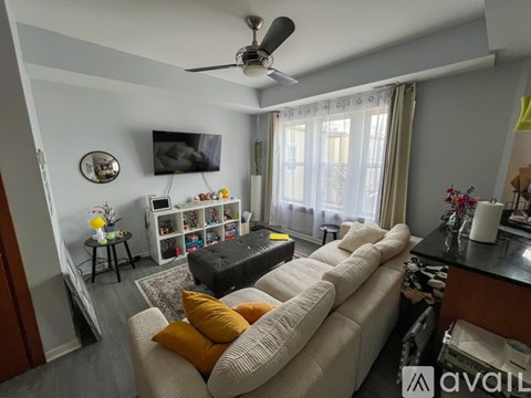 A living room with a white couch and a ceiling fan.