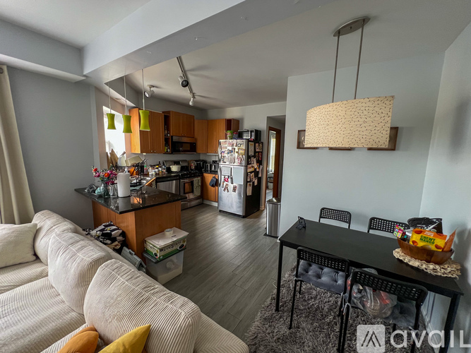 A modern living room with a kitchen in the background.
