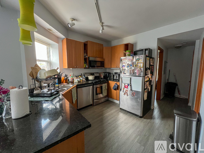 A kitchen with a fridge covered in magnets and notes.