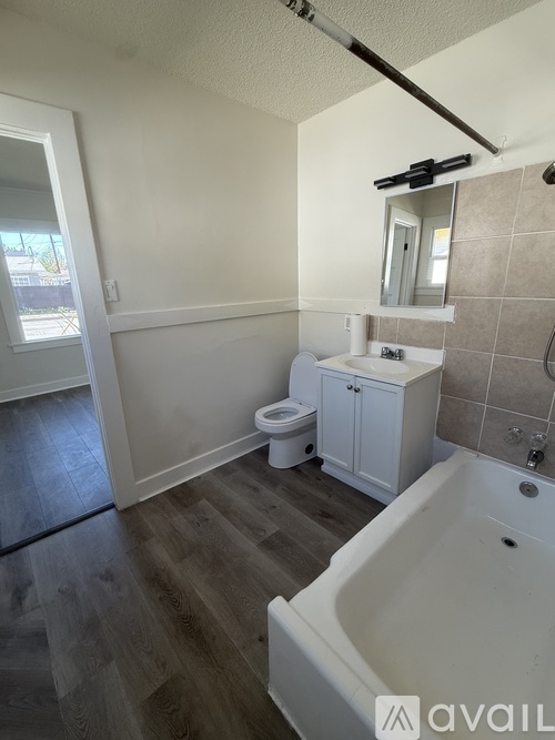 A bathroom with a tub, toilet and sink.