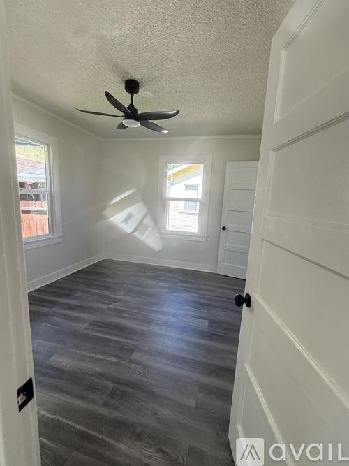 A room with a ceiling fan and a door.