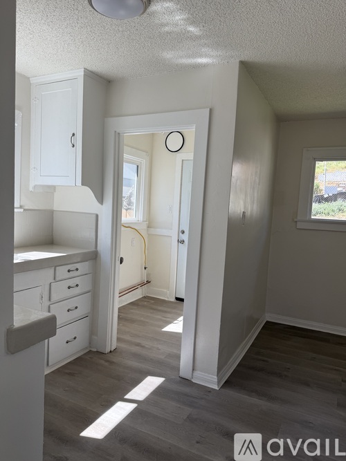 A kitchen with white cabinets and a grey floor.