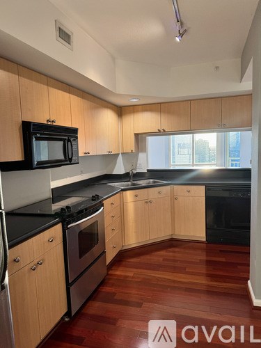 A kitchen with wooden cabinets and black appliances.