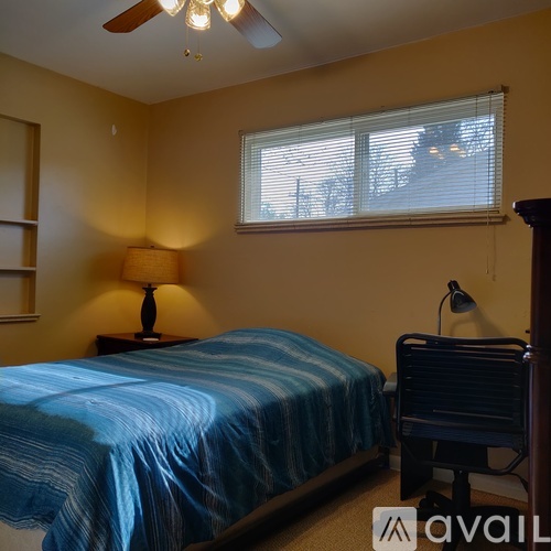 A bedroom with a bed, chair, and two lamps.