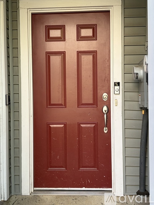 A red door with a silver handle and a silver lock.