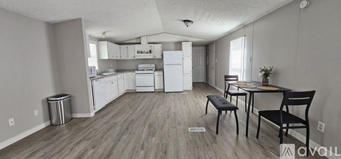 A kitchen with a dining table and chairs in the foreground.