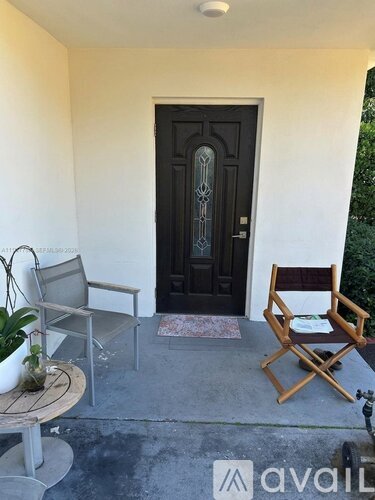 A wooden chair sits on a patio next to a table.